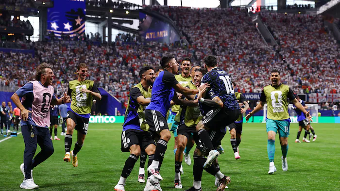 Des joueurs de soccer se regroupent pour célébrer un but.